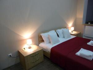 een slaapkamer met een bed met 2 nachtkastjes en 2 lampen bij Old City LG Apartments in Tbilisi City