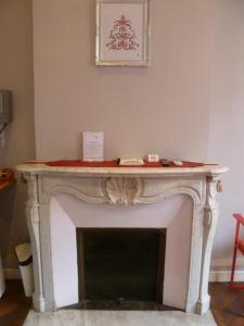 una chimenea en una habitación con un manto blanco en Hotel Victor Hugo Nice, en Niza