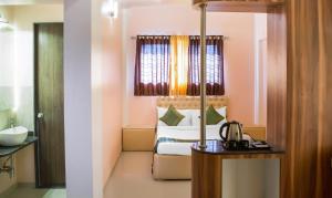 a hotel room with a bed and a table with a coffee maker at Treebo Trend Naunidh Suites in Pune