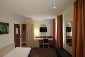 ein Hotelzimmer mit einem Bett und einem Schreibtisch in der Unterkunft Hotel Sonderfeld in Grevenbroich