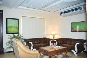 a living room with a couch and a table at Hotel One Sukkur in Kalar Goth