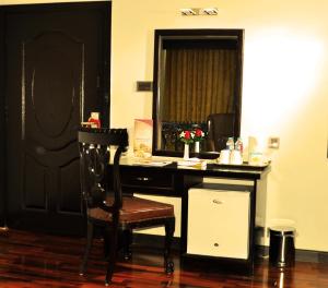 a room with a desk with a chair and a mirror at Hotel One Sukkur in Kalar Goth