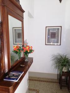 a dressing table with a mirror and flowers on it at Dimora Pieri in Florence