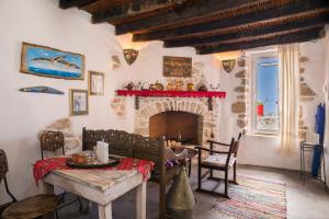 a living room with a fireplace and a table and chairs at Splendid sea view in Mirsíni
