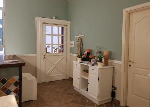 ナポリにあるB＆B デッレ パルメの白いドアと植物のキャビネット付きの部屋