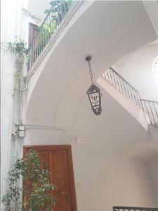 luce di un airndante appesa a un muro bianco accanto a una porta di B&B Delle Palme a Napoli