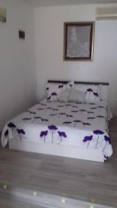 een slaapkamer met een bed met paarse bloemen erop bij Apartmani Vesna in Zambratija