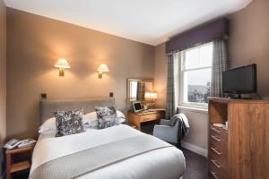 ein Hotelzimmer mit einem Bett und einem TV in der Unterkunft Ardgowan Hotel in St Andrews