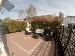 a patio with couches and chairs on a brick floor at Doma 4.2 in Riccione