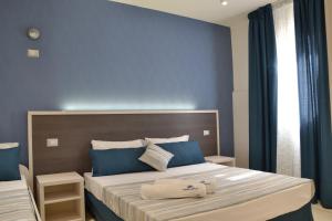 a bedroom with two beds with blue walls at Affittacamere Torre Lapillo in Torre Lapillo