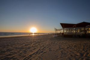 a sunset on the beach with the sun setting at Hipotels Barrosa Park in Chiclana de la Frontera