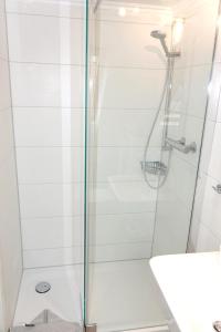 a bathroom with a shower with a glass door at BORKUMUNTERKUNFT - WOH2 - IM HERZEN DER INSEL in Borkum