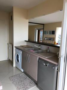 een keuken met een spoelbak en een wasmachine bij Le Fourneau beach in Fréjus