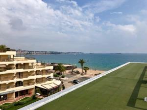 Blick auf ein Gebäude und das Meer mit Strand in der Unterkunft Le Fourneau beach in Fréjus