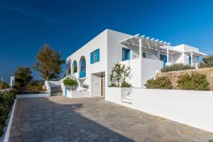 a white villa with a pathway in front of it at Eiriana Luxury Suites in Plaka Milou