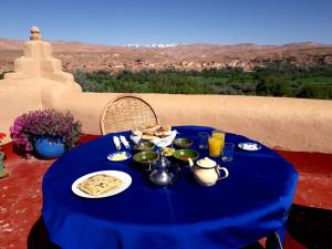 a blue table with food on it with a view at Les Jardins du M'goun in El Kelaa des Mgouna