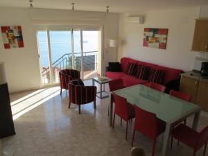 ロザスにあるTuro marina 3のリビングルーム(赤いソファ、テーブル、椅子付)