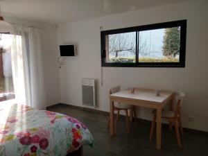 a bedroom with a table and a bed and a window at Boizen in Saint-Jean-de-Boiseau
