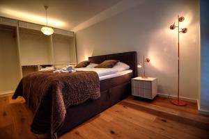 a bedroom with a large bed and a lamp at Plenus Riverloft in Bremen