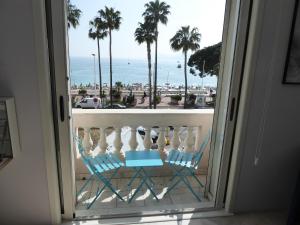 a balcony with two chairs and a view of the ocean at Residence Palais Miramar in Cannes