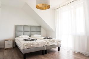 a white bedroom with a large bed and a chandelier at Hostel 66 in Krosno