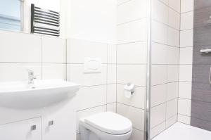 La salle de bains blanche est pourvue d'un lavabo et de toilettes. dans l'établissement Hostel 66, à Krosno