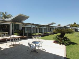 un edificio con sillas y mesas en un patio en Hotel Camberland en Pilar