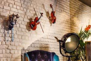 a wall with three violins hanging on a brick wall at ibis Styles London Southwark - near Borough Market in London
