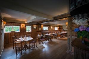 a restaurant with wooden walls and tables and chairs at The Hawk Inn in Andover
