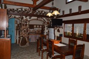 a dining room with a table and chairs and a tv at Giardino degli Ulivi in Gonnesa