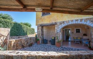 a stone building with an archway and a patio at Belvedere Suites - Klodge in Olbia