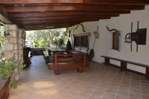 patio z drewnianym stołem i ławką w obiekcie Giardino degli Ulivi w mieście Gonnesa