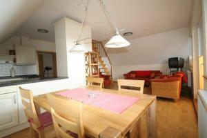 a kitchen and living room with a wooden table and chairs at Nickelshus-Whg-Lars in Sankt Peter-Ording