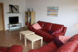 a living room with a red couch and a tv at Nickelshus-Whg-Birte in Sankt Peter-Ording