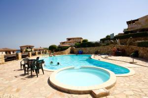 a large swimming pool with chairs and people in it at Belvedere Suites - Klodge in Olbia