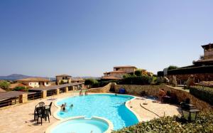 a large swimming pool with people sitting around it at Belvedere Suites - Klodge in Olbia