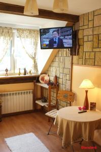 a living room with a table and a tv on the wall at Zajazd Wiejski in Szczechy Wielkie