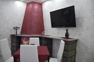 a living room with a fireplace with a tv on a wall at Il Cuore dell'Etna in Belpasso