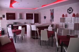 a kitchen and dining room with white tables and chairs at Il Cuore dell'Etna in Belpasso