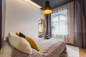 Un dormitorio con una cama con almohadas amarillas y una ventana en Zillmann Apartment, en Katowice