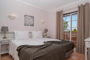 a bedroom with a white bed and a window at Colina da Lapa & Villas in Carvoeiro +67 photos