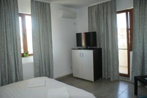 ママイア・ノルドにあるApartment Sun Mamaia Nordのベッドルーム1室(ベッド1台、テレビ付)
