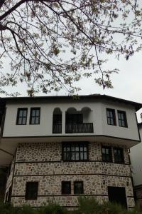 a stone building with a balcony on top of it at Guesthouse White Margarit in Melnik +49 photos