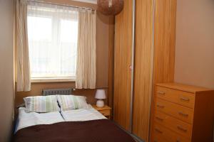 1 dormitorio con cama, ventana y vestidor en Apartament Maryla en Giżycko