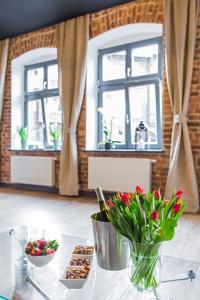 a table with a vase of flowers and some treats at Zillmann Apartment in Katowice