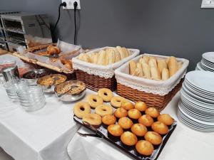 a table with baskets of bread and pastries on it at Hostal El Altet in El Alted