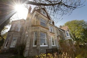 un viejo edificio de ladrillo con el sol brillando en él en YHA Swanage en Swanage