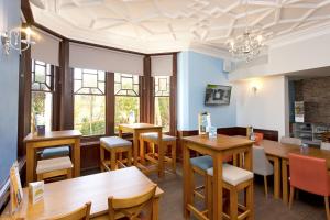 a restaurant with wooden tables and chairs and windows at YHA Swanage in Swanage