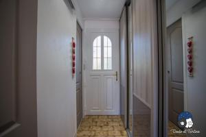 korytarzem z białymi drzwiami z oknem w obiekcie Quiet studio with garden and pool - Dodo et Tartine w mieście Peypin