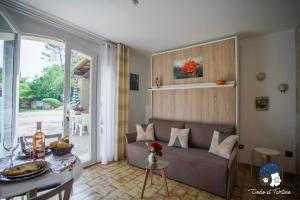 een woonkamer met een bank en een tafel bij Quiet studio with garden and pool - Dodo et Tartine in Peypin